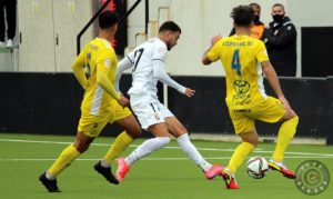 Luis Alcalde, entre dos jugadores del San Fernando, en el partido del pasado domingo en el Murube