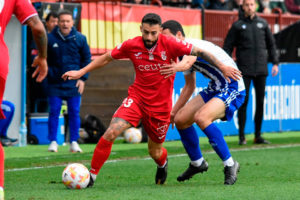 Ñito González conduce el balón con la presión de un jugador del Talavera