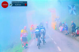 Captura de la televisión al paso de los ciclistas por la pancarta de los últimos cinco kilómetros 