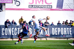 Martín Bellotti disputa un balón aéreo entre dos jugadores del Yeclano