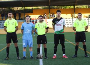 Los capitanes de ambos equipos, junto al trío arbitral